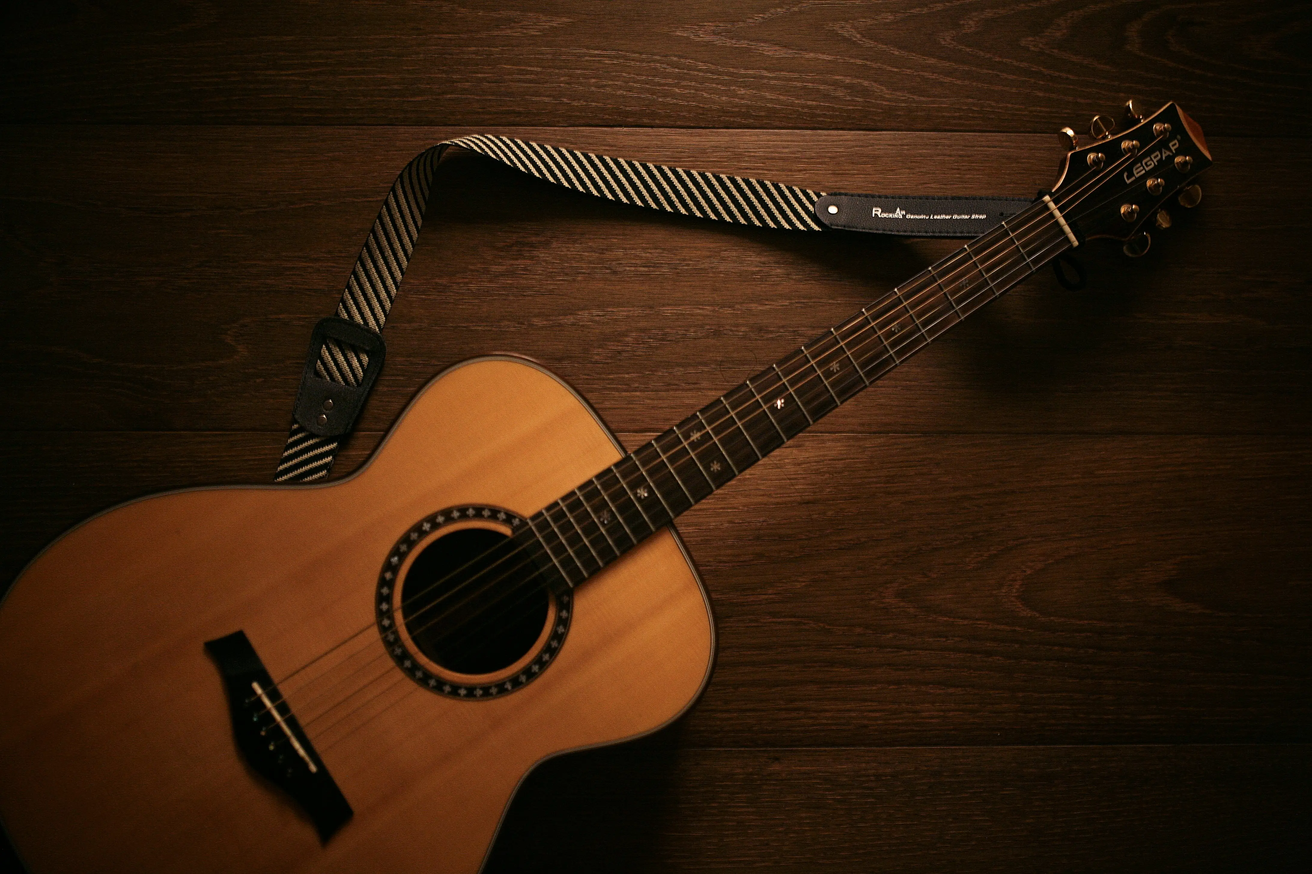 Acoustic guitar leaning against a textured wall